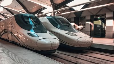 Two modern high-speed trains parked at the Madinah station platform under a sleek roof at Saja Warwick Madinah