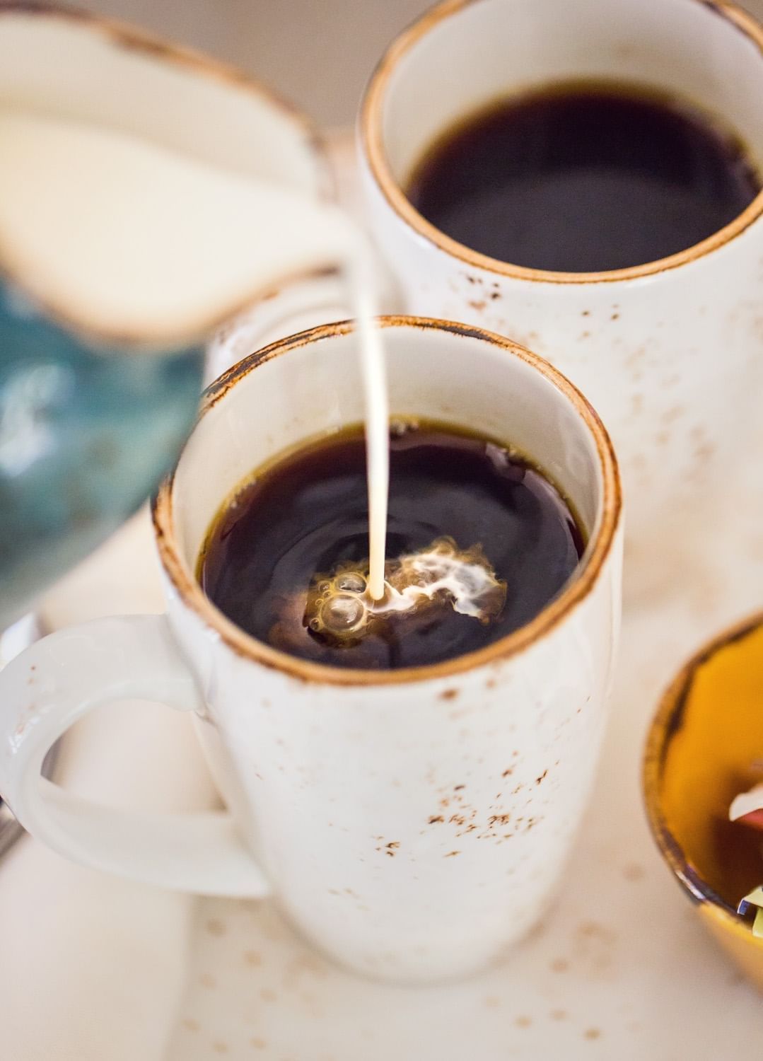 Lorem ipsum Cream being poured over a cup of coffee