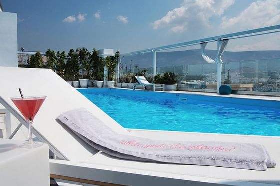 Outdoor pool with sunbeds at St. George Lycabettus