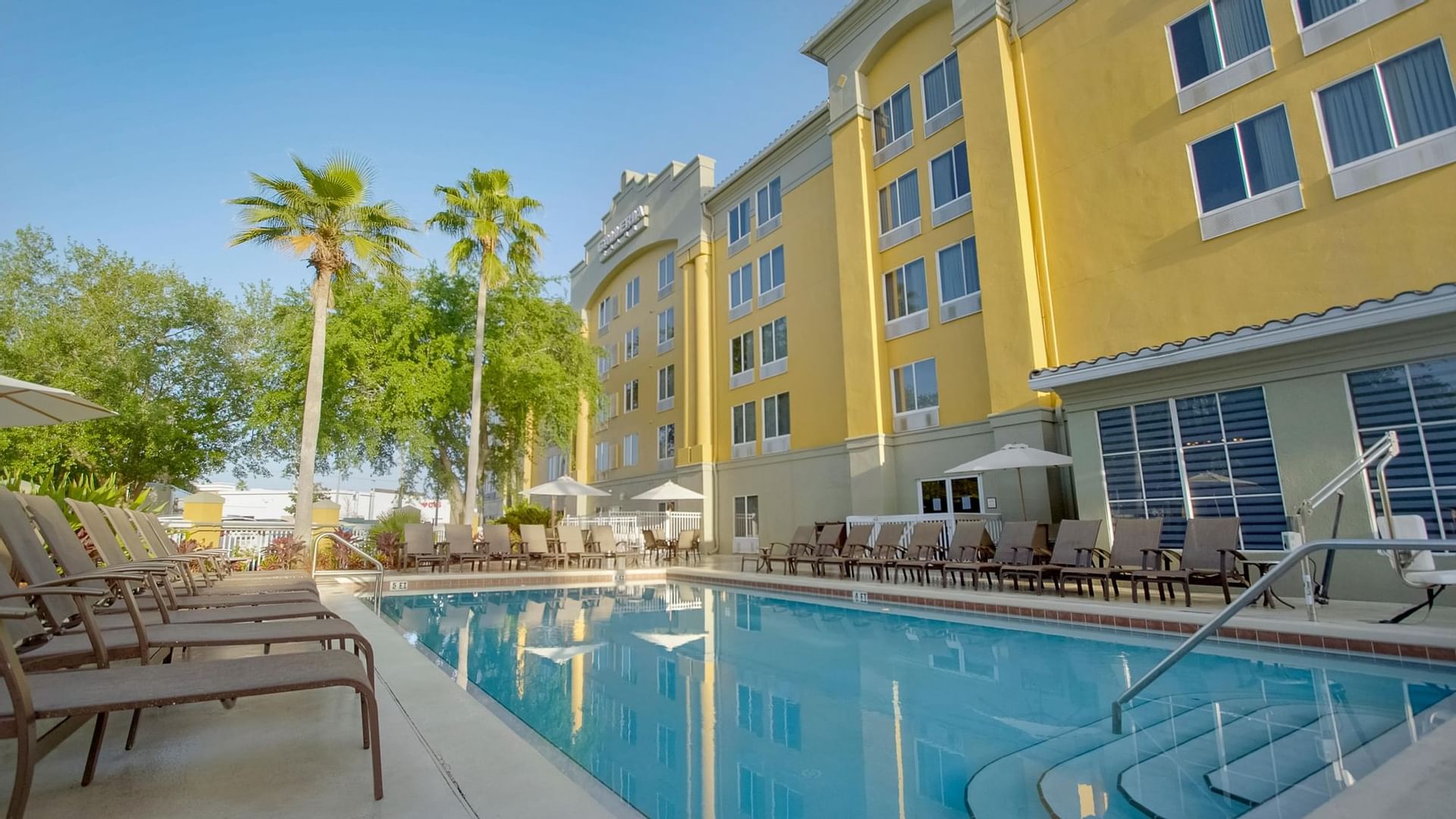 Pool with lounge chairs at Galleria Palms Hotel, Kissimmee hotel with heated outdoor pool near Disney