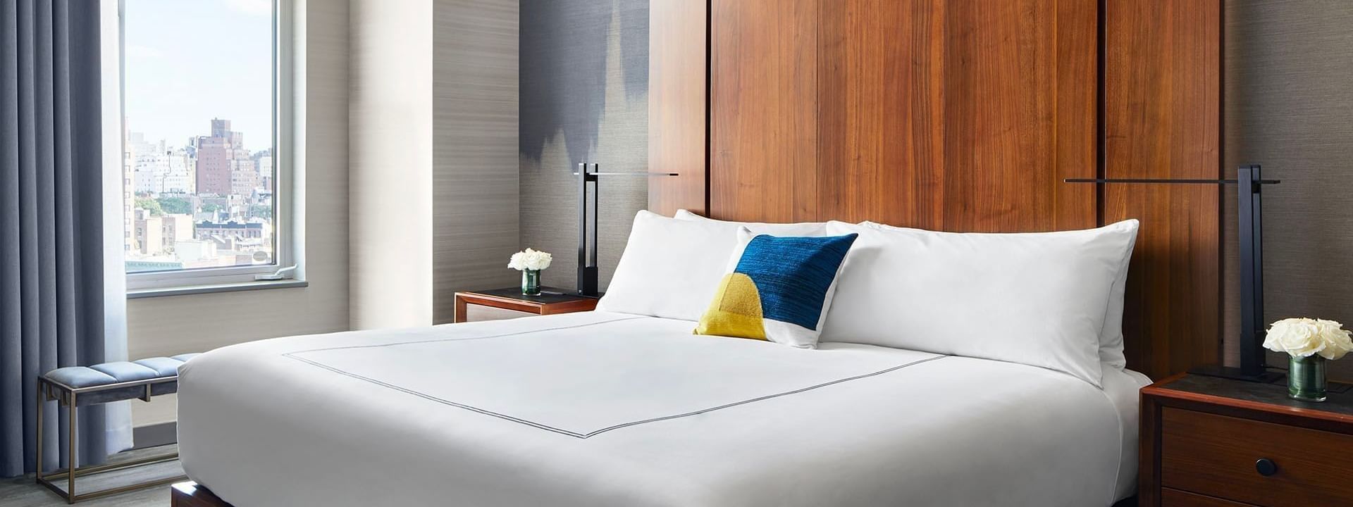 Cozy king-sized bed with modern bedside lamp in Manhattan Suite at Gansevoort Meatpacking NYC