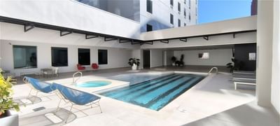Outdoor pool area with loungers and comfy chairs at D Sabana Hotel, hotels in San Jose Costa Rica