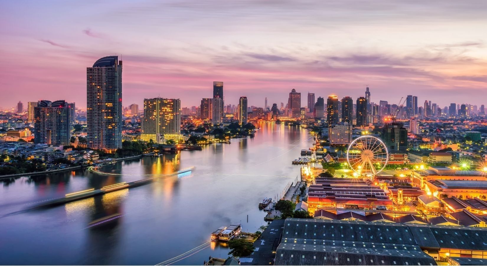 Aerial view of the Bangkok cityscape with illuminated skyscrapers and river at Paradox Hotels and Resorts Portal