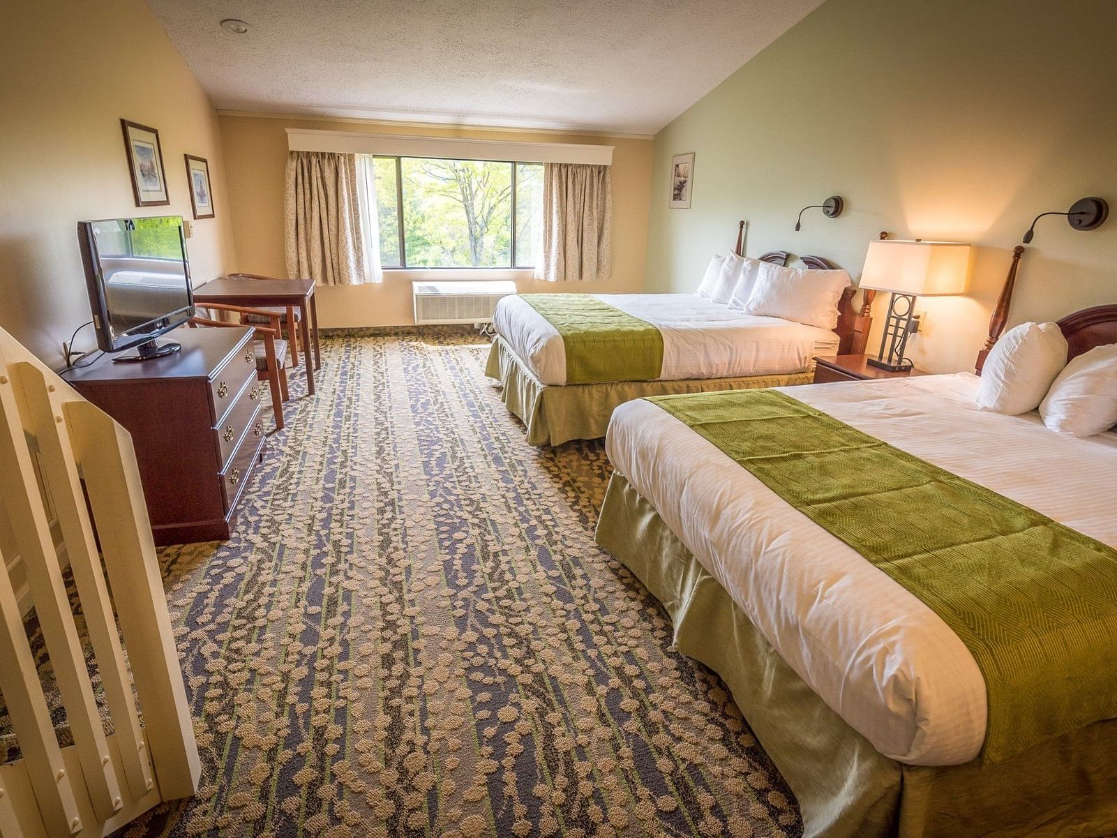 Two beds with green and white linens in a room at Fox Ridge Resort in Conway.