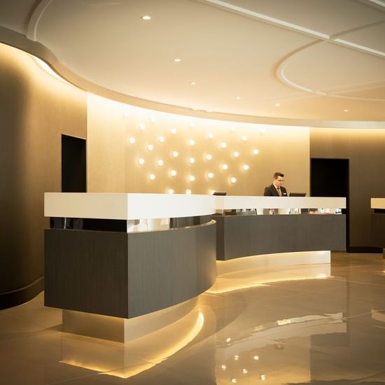 Receptionist by illuminated front desk at Pullman Albert Park