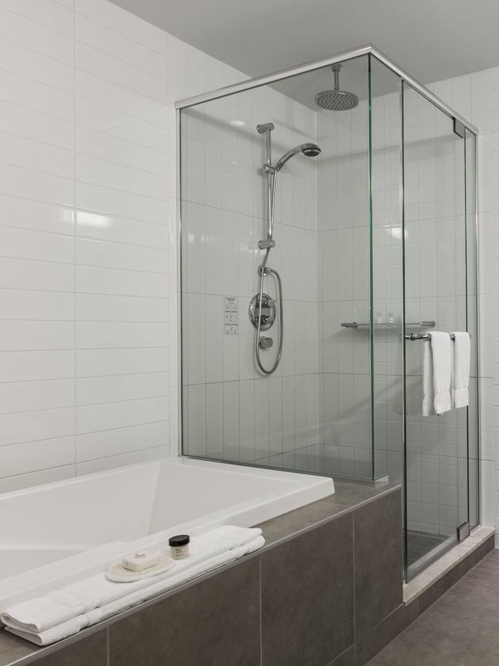 Salle de bain avec douche et lavabo dans la suite Junior du Warwick Le Crystal