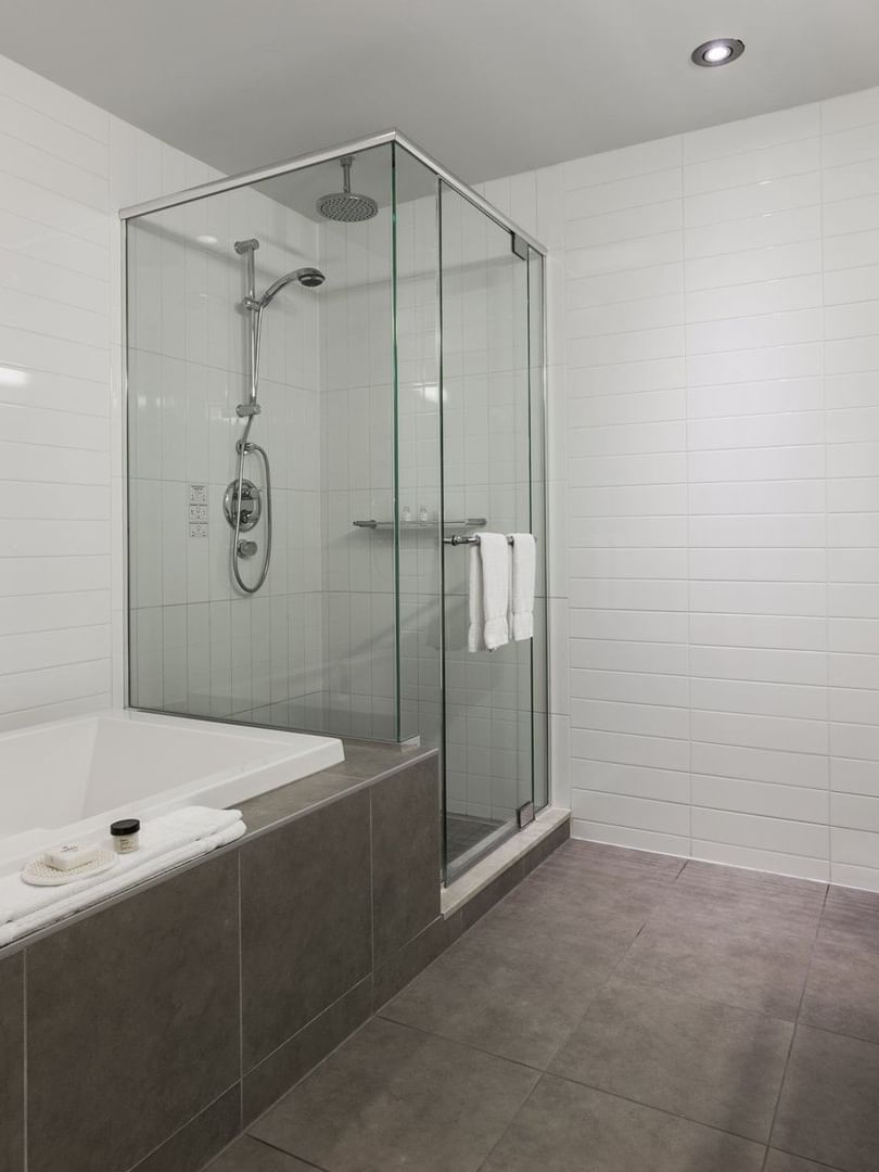 Salle de bains de la suite Loft avec douche et baignoire au Warwick Le Crystal
