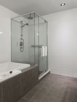 Salle de bains de la suite Loft avec douche et baignoire au Warwick Le Crystal