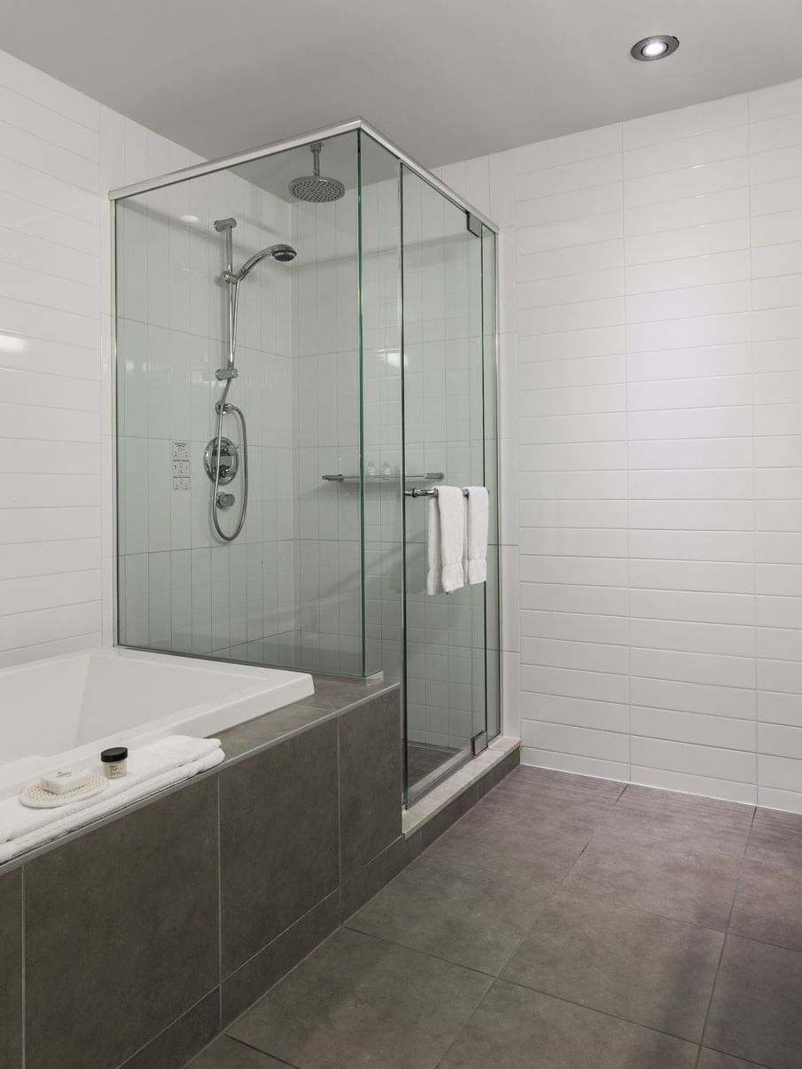 Loft Suite bathroom with shower area and bathtub at Warwick Le Crystal Montreal
