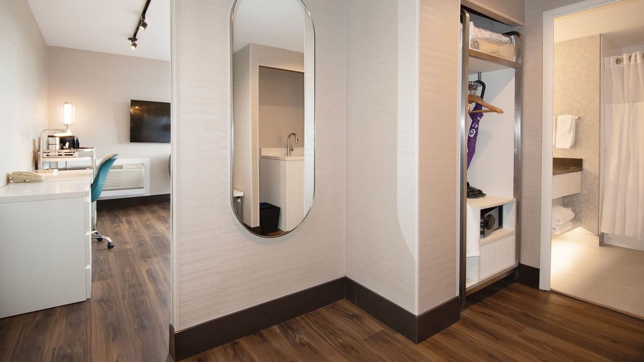 Hotel guestroom hallway to bathroom with a mirror.