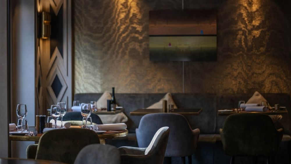 Restaurant & Bar area with soft lighting and textured walls & dark marble desk at Hotel Barsey by Warwick