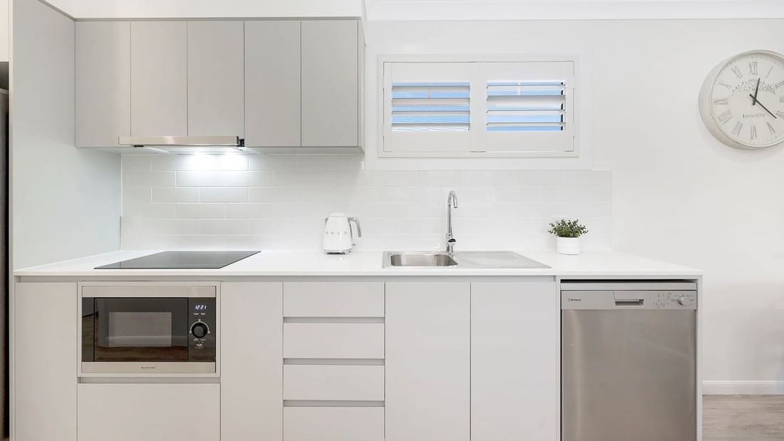 Deluxe Bungalow 2 Bedroom kitchen featuring sleek cabinetry, a countertop, and appliances at Mercure Hotel Townsville