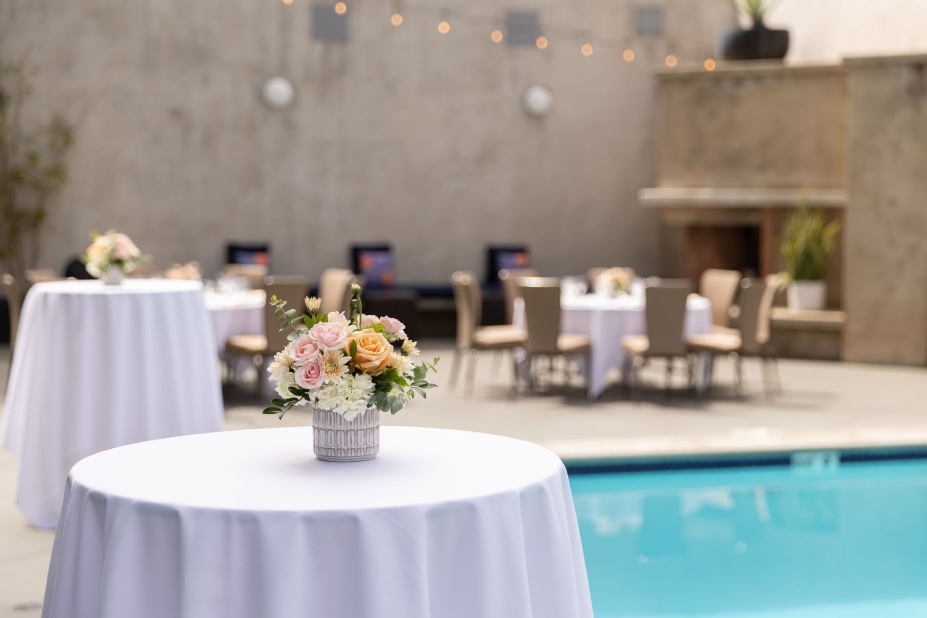 a poolside area with tables and chairs set up for an event