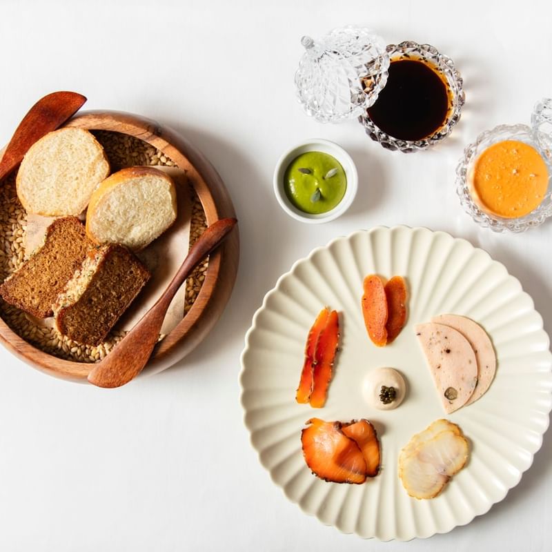 Spread of assorted meats, bread, and dipping sauces at Warwick Hotels and Resorts, showcasing the culinary excellence