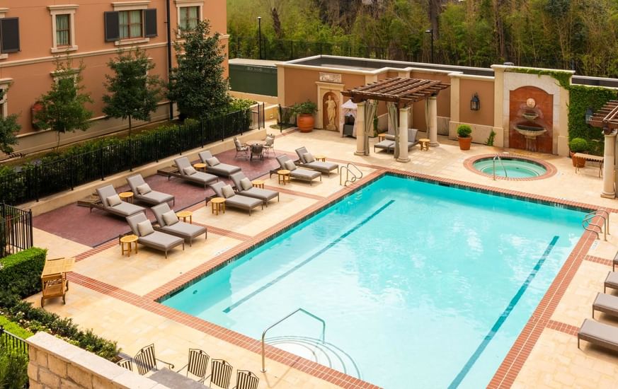 Sunny pool area at Granduca Houston, one of the top Houston hotels with pools, featuring lounge chairs