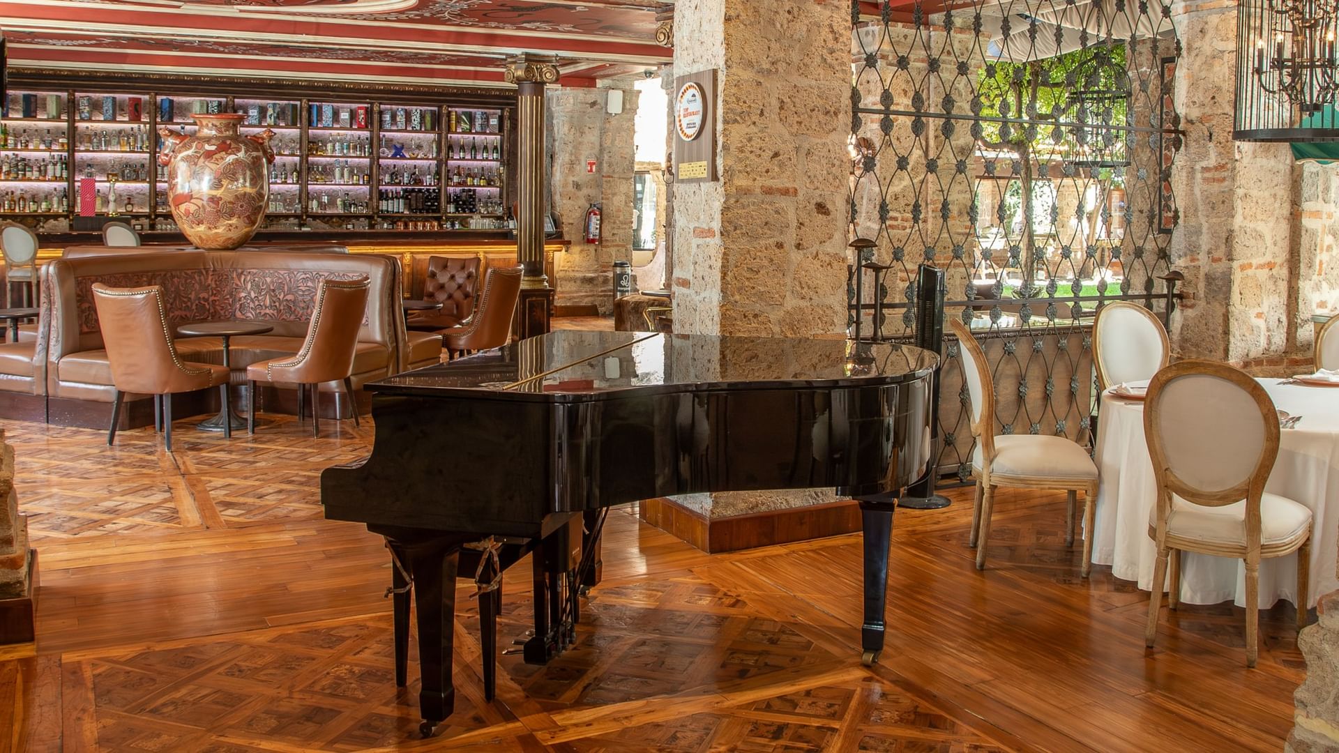 Tierra Mia restaurant interior with grand piano, elegant seating, and decorative ironwork at Quinta Real Guadalajara