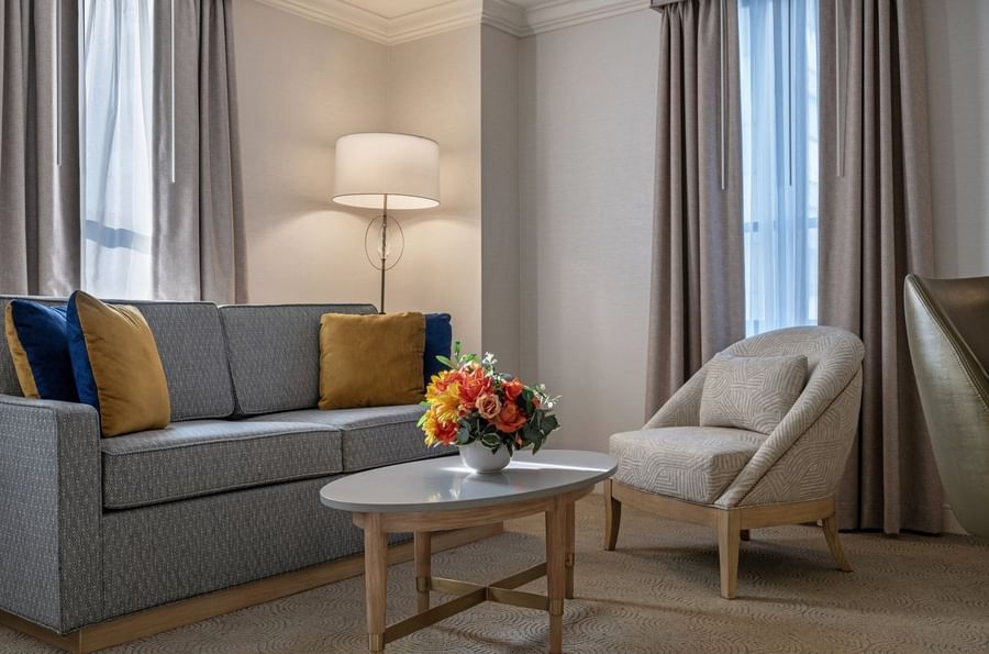 Sofa with coffee table near floor lamp in Premium Suite Two Queen Beds at Warwick Allerton Chicago