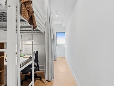 Bunk beds and a desk with chair in a room at UniLodge Brisbane City.