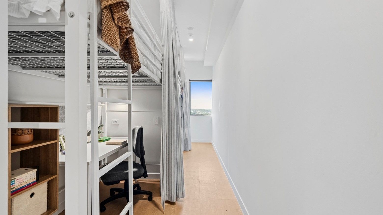 Bunk beds and a desk with chair in a room at UniLodge Brisbane City.