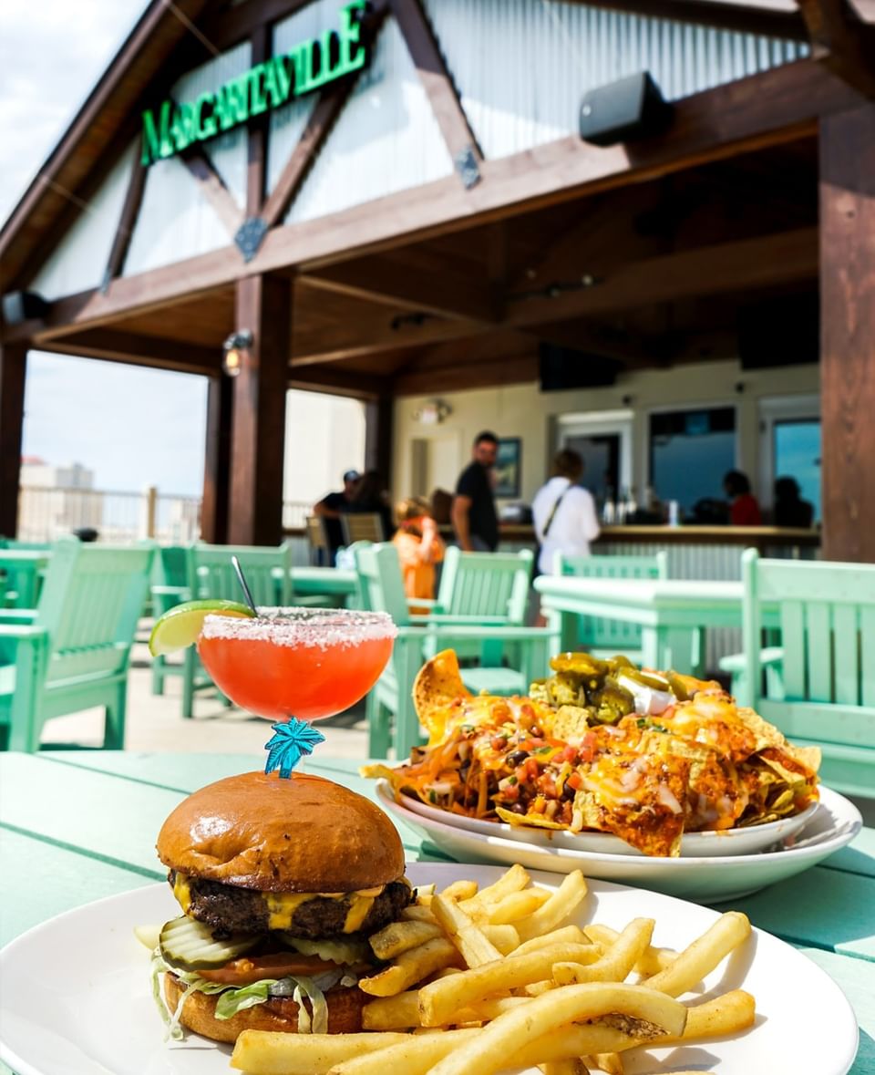 Juicy cheeseburger, fries, and nachos served in Margaritaville Café at Margaritaville Resort Biloxi