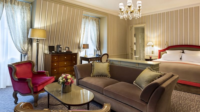 Elegant bedroom with lounging area and large bed in Deluxe Parisian suite at Hôtel Westminster - Paris
