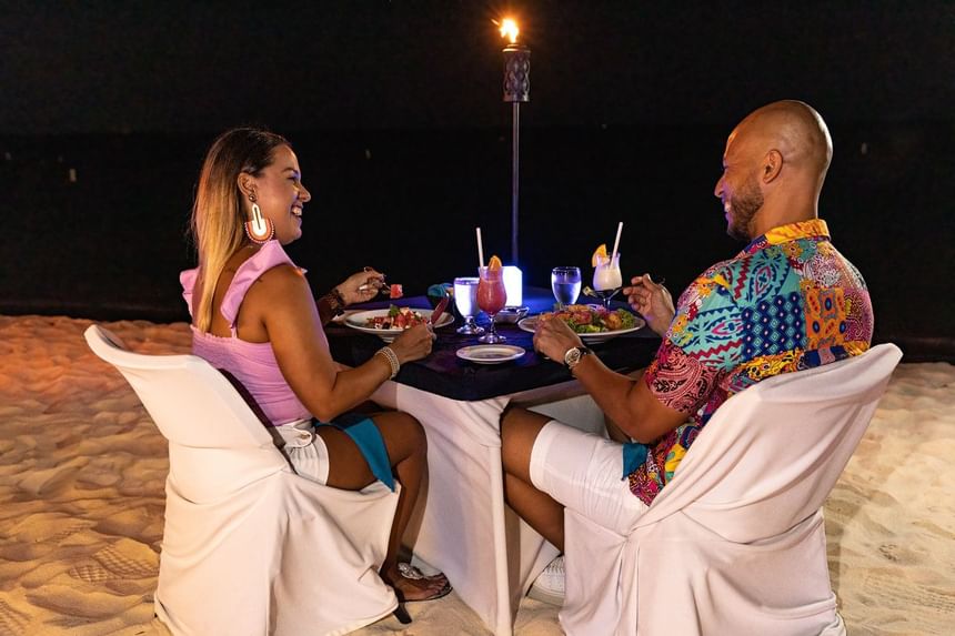 A couple having dinner by the beach at Amsterdam Manor Resort