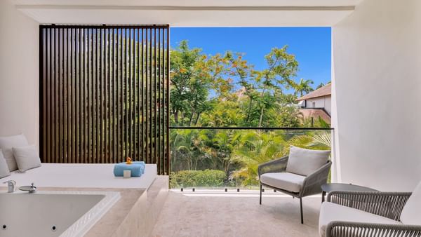 Bathtub by the spa bed and seating area in Premium Garden View room at Live Aqua Punta Cana