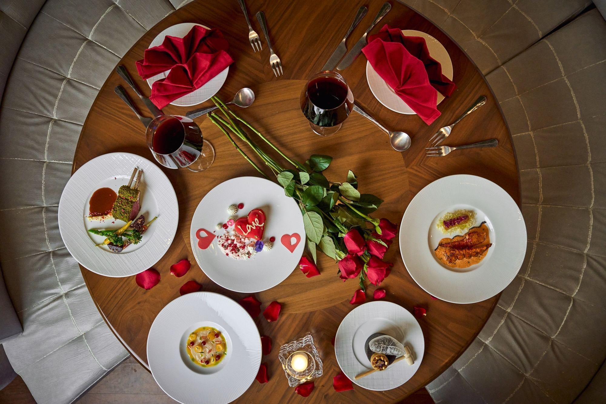 Dining table arranged with heart-shaped cake, dishes  and wine at Paramount Hotel Dubai