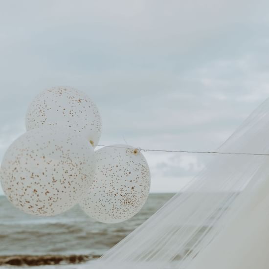 Bride running with balloons at Pullman Palm Cove Sea Resort