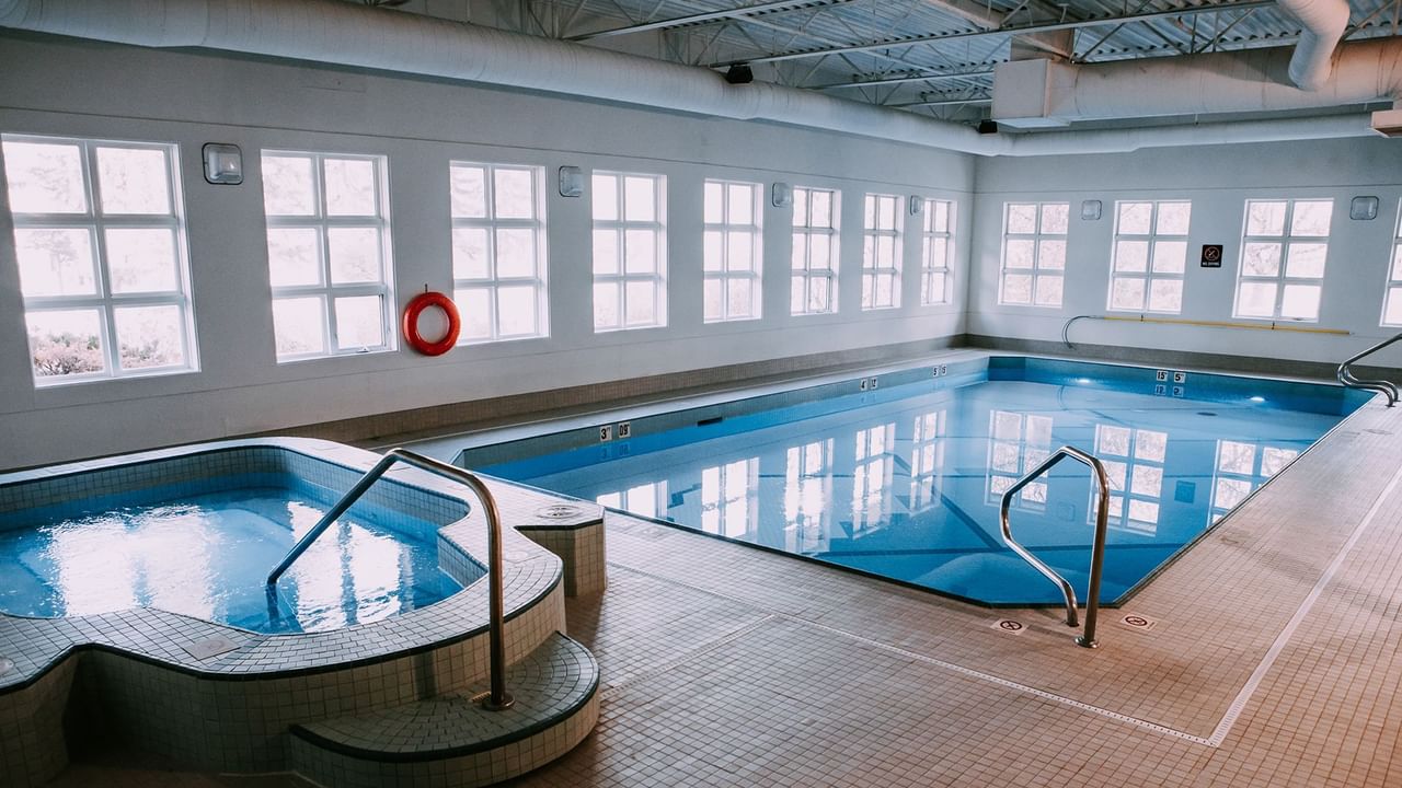 An indoor pool area with a pool and a hot tub.
