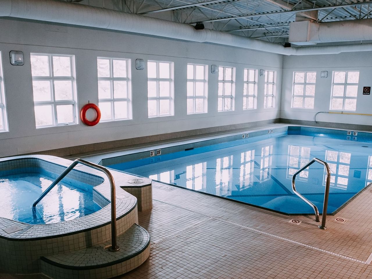 An indoor pool area with a pool and a hot tub.