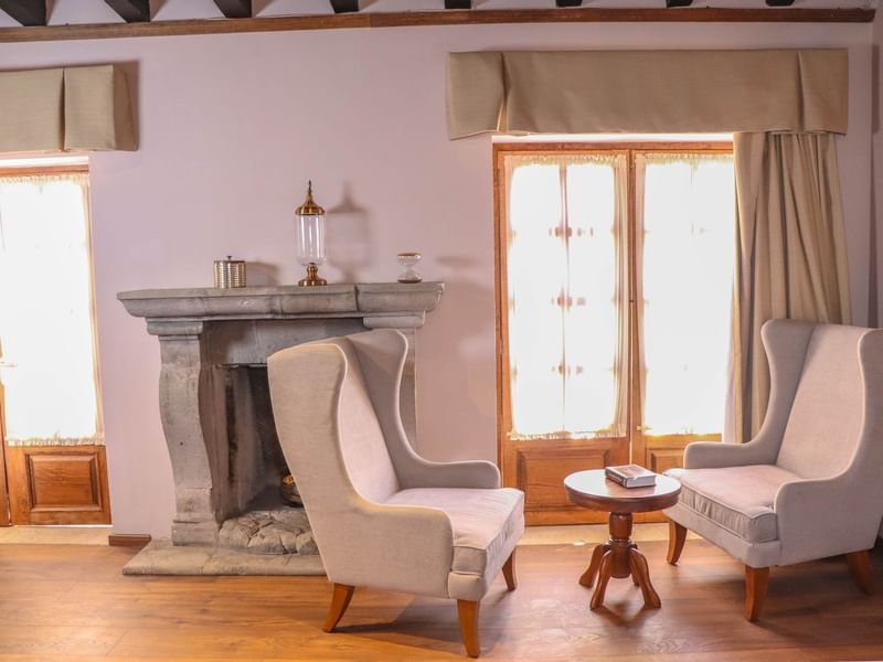 High back chair near fireplace in Junior Suite at Gamma Hotels