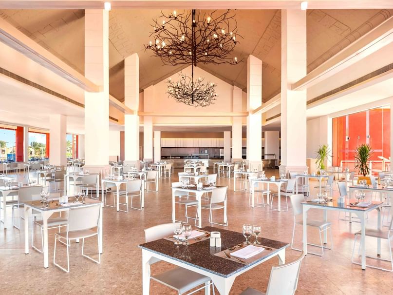 Elegant dining area with tables and chairs under decorative lighting at Pickalbatros Laguna Club Resort in South Sinai Governorate.