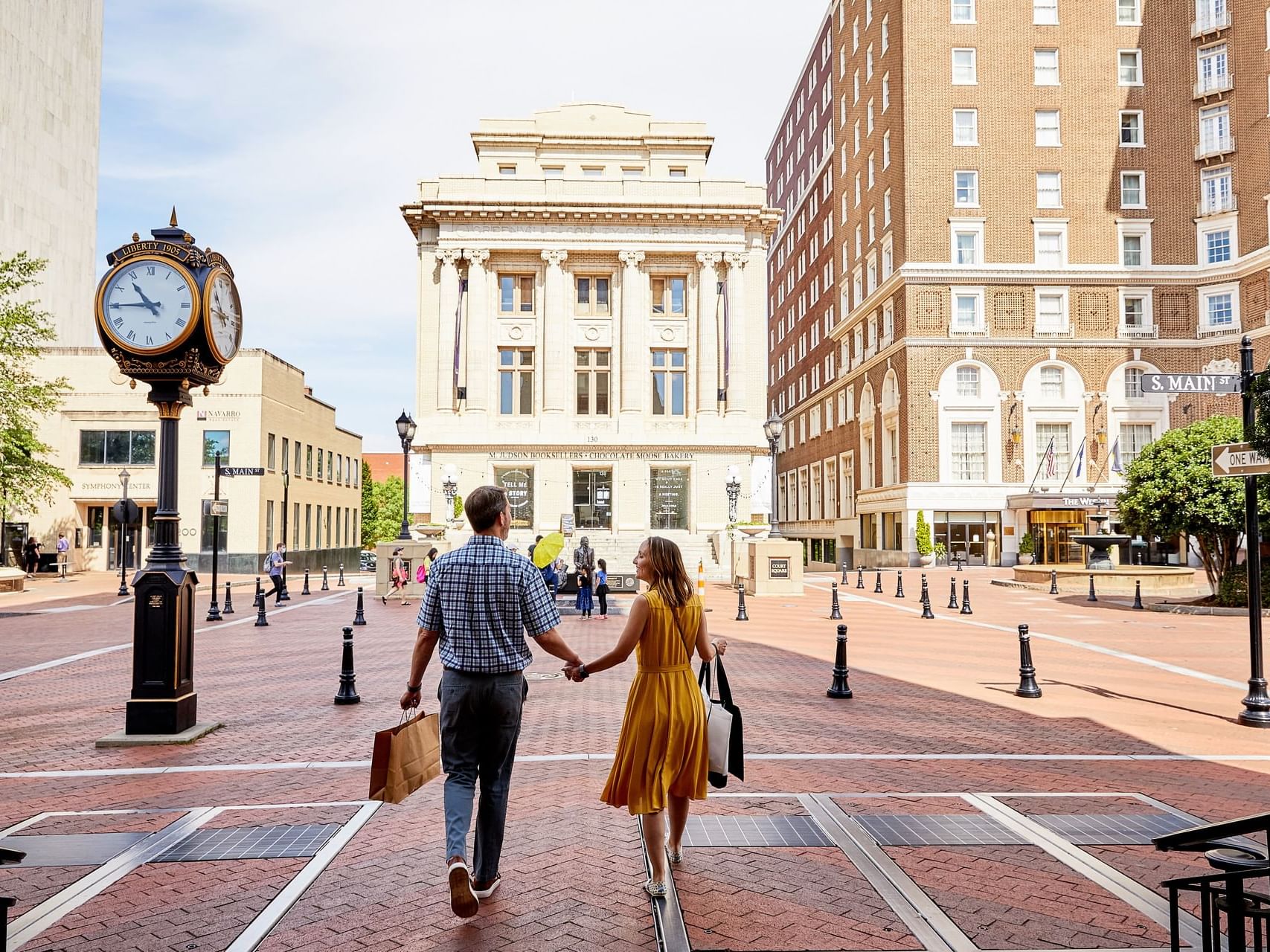 Couple walking holding hands in Greenville near Hotel Hartness