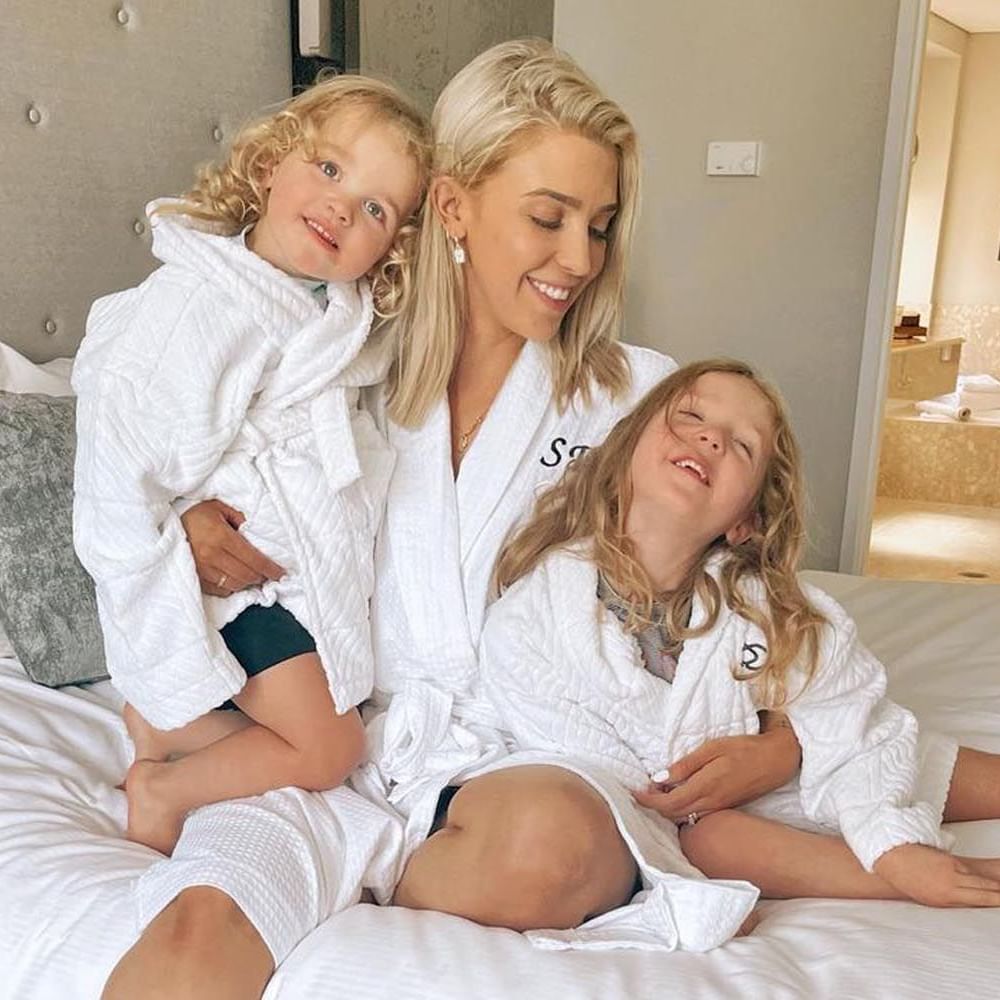Mother with her children in bathrobes and spends time with on a bed at Sofitel Brisbane Central