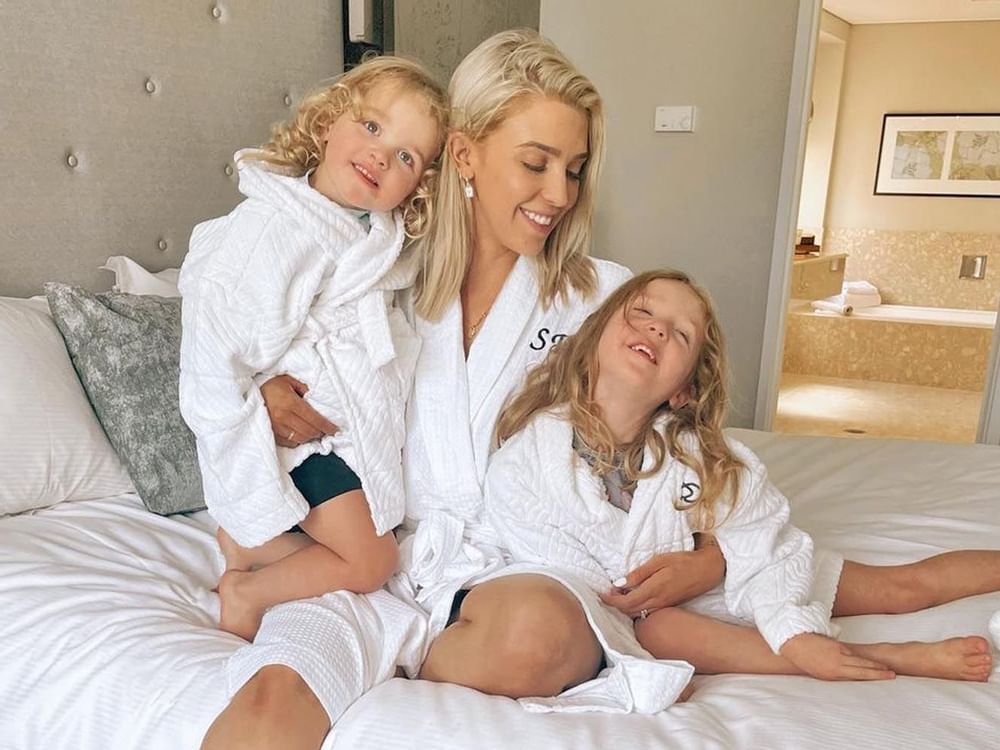 Mother with her children in bathrobes and spends time with on a bed at Sofitel Brisbane Central