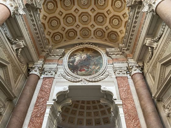 Grand ceiling adorned with an intricate painting in Basilica of Saint Mary of the Angels and Martyrs near Bettoja Hotels Group