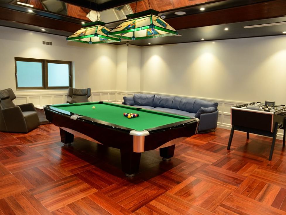 room with pool table, soccer table and lounge chairs