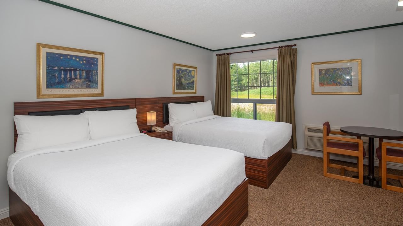 guest room with two queen beds, desk, chair and window at Coast Whitecourt Hotel
