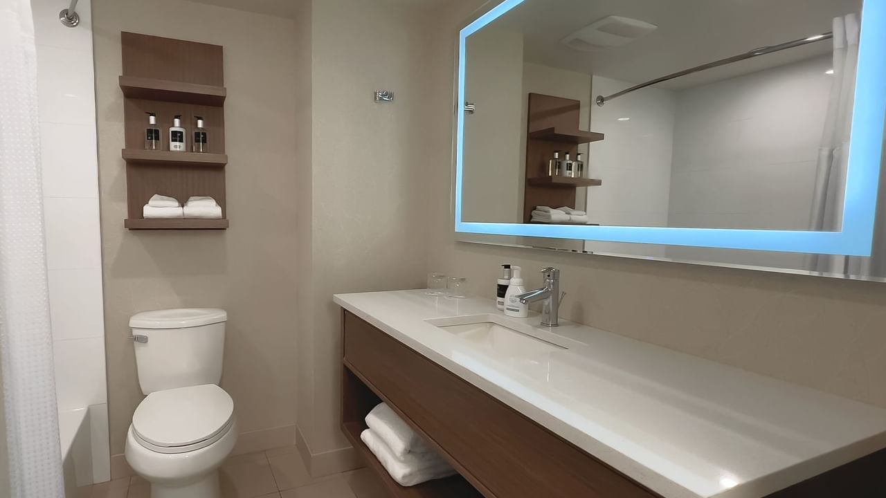 Bathroom with mirror, sink, toilet, wall cabinet, towels