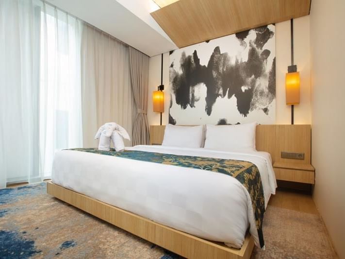 Beds and nightstand in King Deluxe Room at LK Cikarang Hotel & Residences