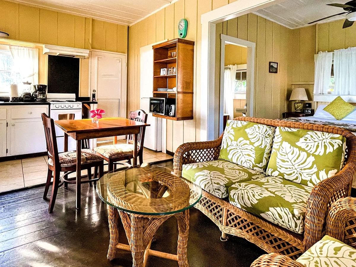 Waimea Plantation Cottages living bedroom with kitchen, couch, and table