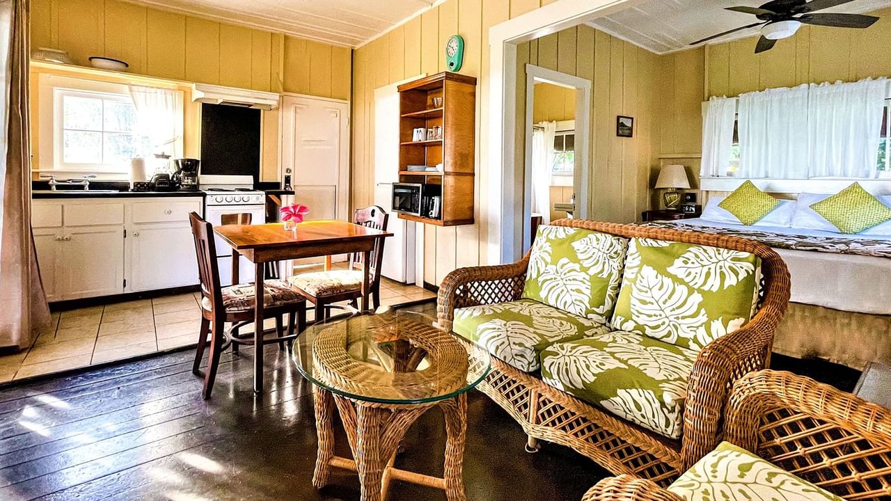 Waimea Plantation Cottages living bedroom with kitchen, couch, and table