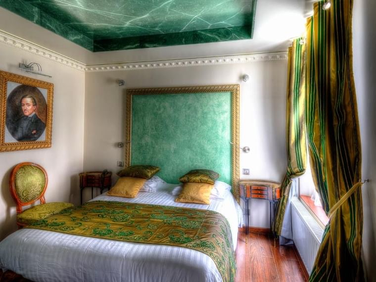 Chambre Excellence élégante avec lit, peinture et fauteuil à l'Hôtel Villa Aultia à Ault.
