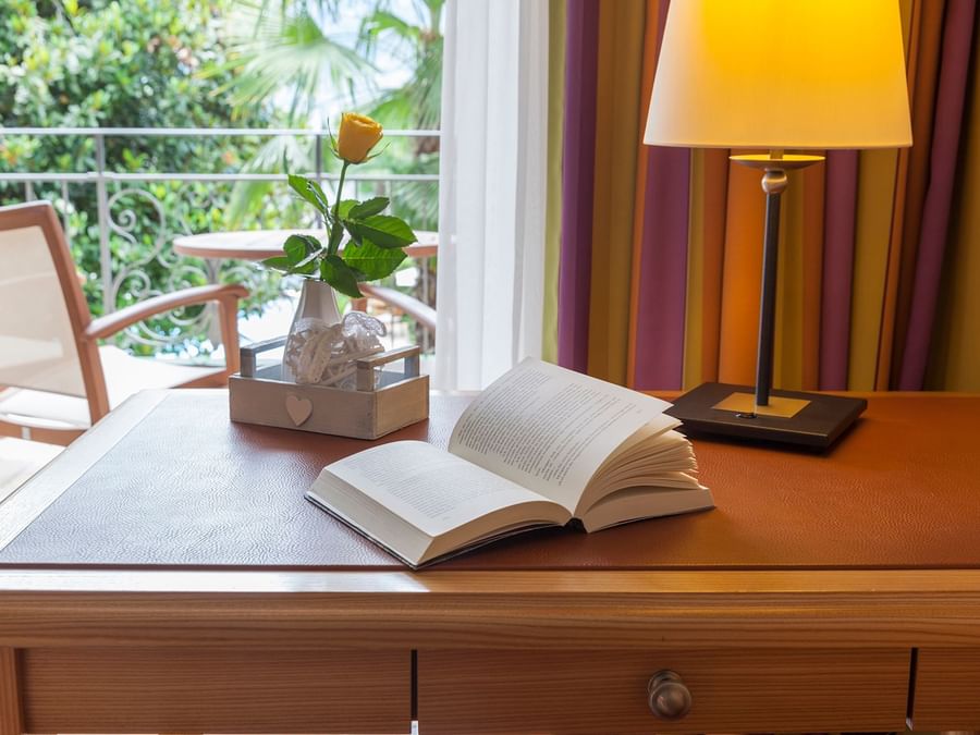 A book & a table lamp on a table at Boutique-Hotel Remorino