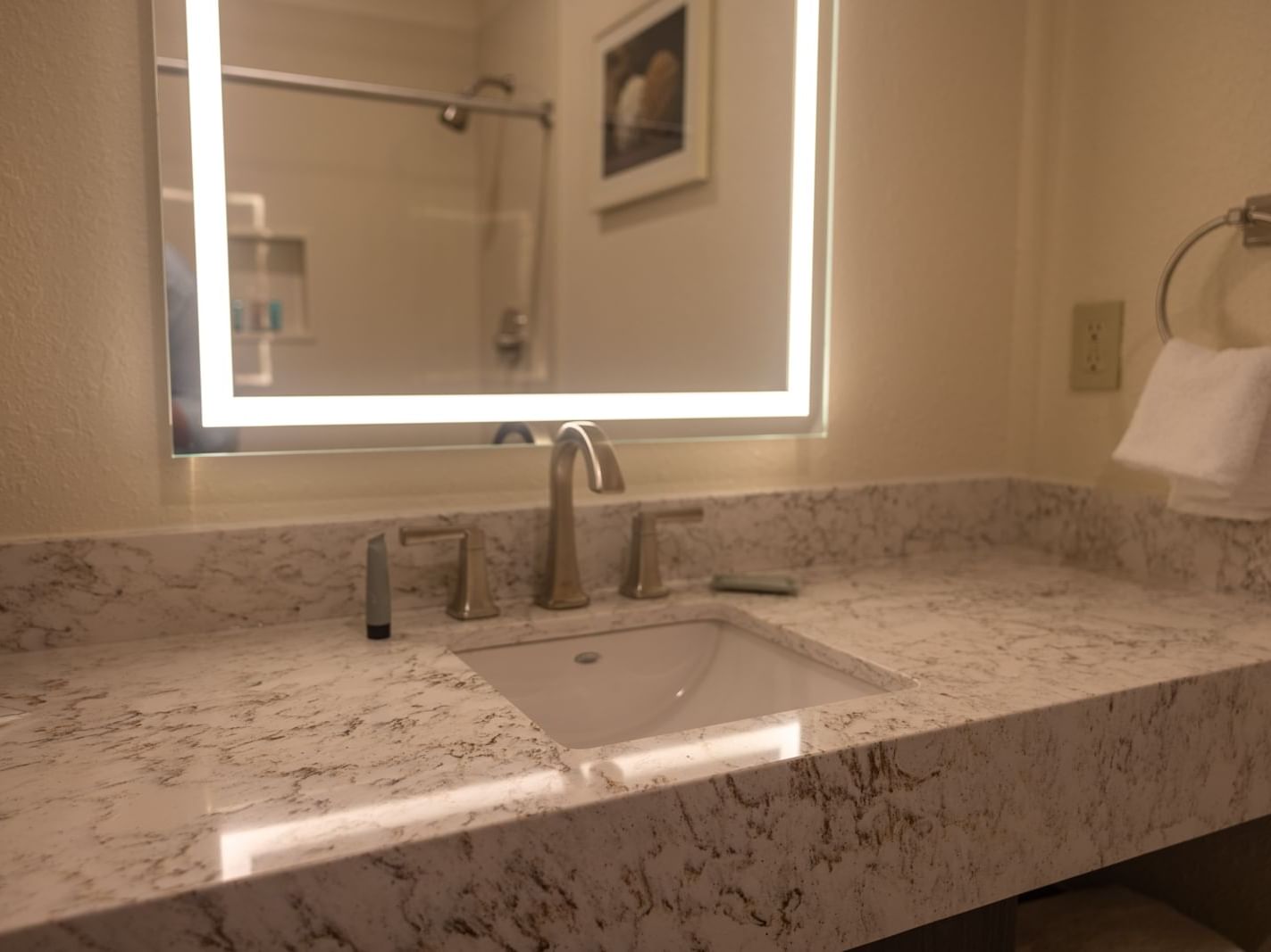 A bathroom sink with a lighted mirror in DRI Two Queen Beds - Non-Smoking at Pearl River Resorts