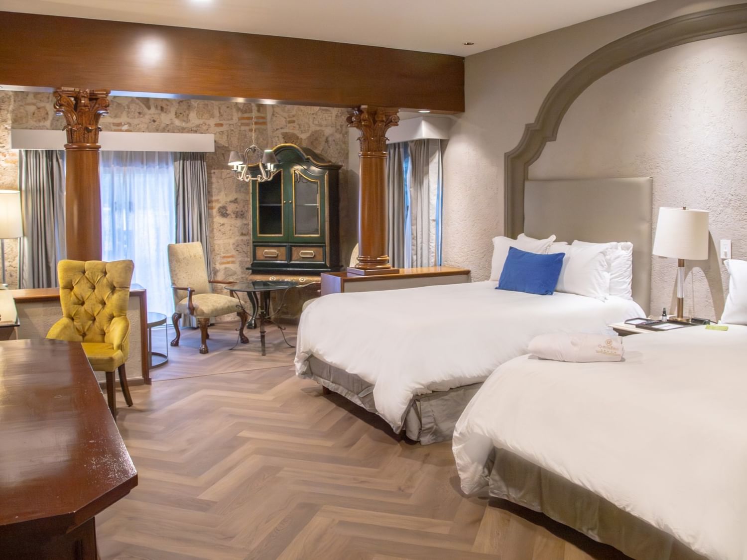 Spacious 2 Double Master Suite with herringbone floors, two beds, arched alcove, and colonial-style decor at Quinta Real Guadalajara