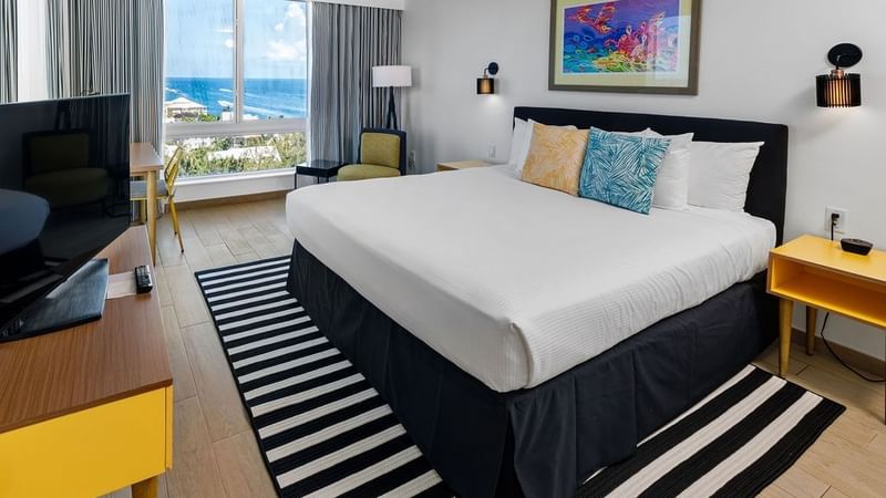 King-size bed, work desk & a TV in Water View at Warwick Paradise Island Bahamas