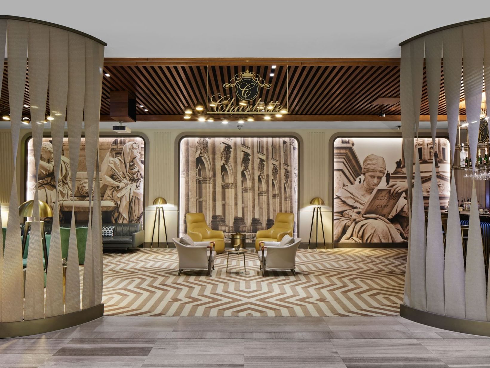 Elegante Lobby mit geometrischem Boden, gelben Sesseln, Wandgemälden und Kronleuchter – Titanic Chaussee Berlin.
