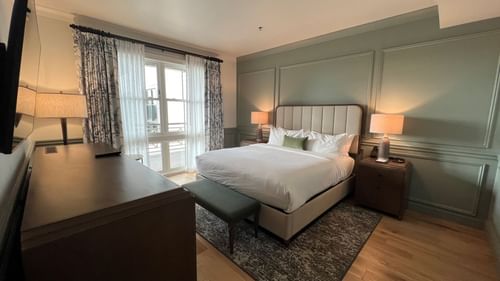 Drawer & TV facing the king bed in Pine Suite with wooden floors at Camp Creek Inn